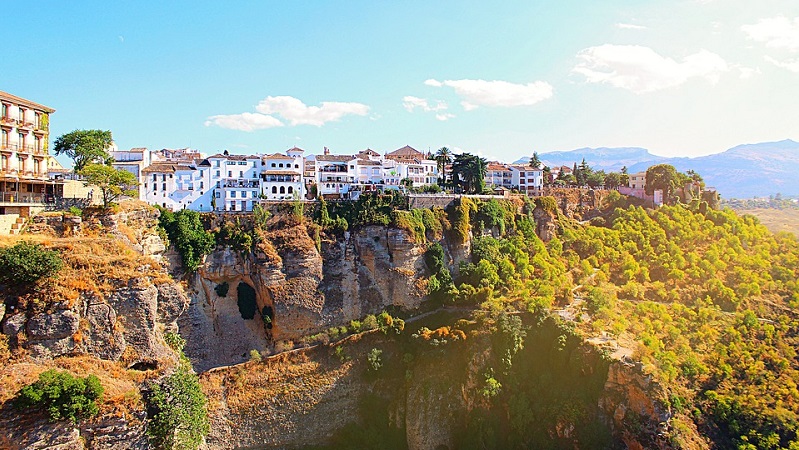 Genuina Ronda Ronda, en stad byggd på klippor, med vitkalkade hus och grönskande landskap.