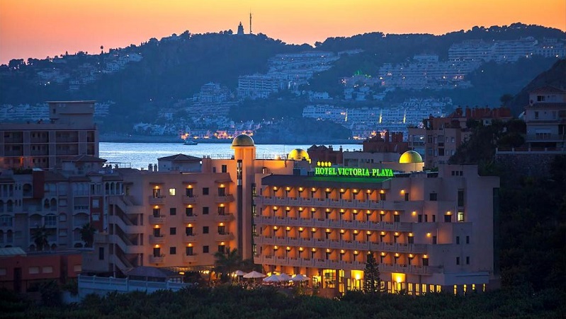 Hotel Victoria Playa Hotel Victoria Playa lyser upp skymningen med bergen och havet som vacker bakgrund.