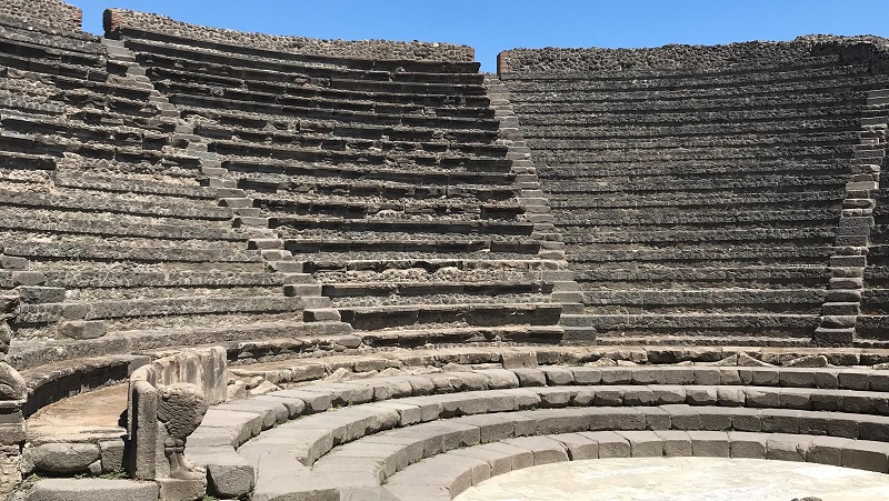 Pompeji Antikt amfiteater i Pompeji med stenläktare under klarblå himmel.