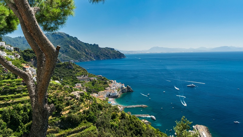 Amalfikusten Amalfikusten med grönskande terasser, klarblått hav och båtar längs den branta, pittoreska kusten.