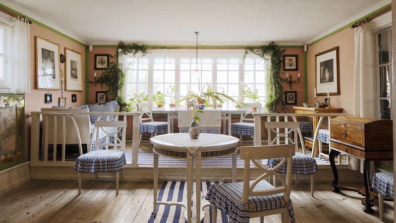 Carl Larssongården  Ett rum i sekelskiftesmiljö med vita och blå klädsel på möbler