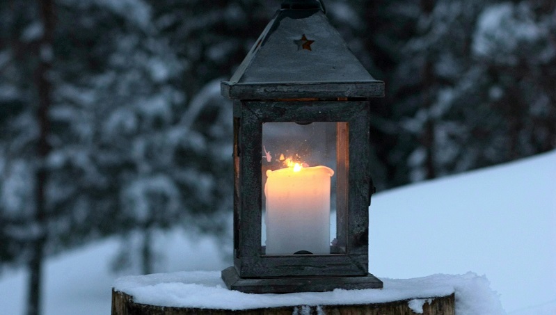 ljus i lykta med vacker vintermiljö i bakgrunden