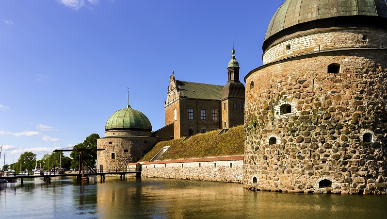 Vadstena slott Bild på Vadstena slott med vallgraven framför. Spegelblankt vatten framför slottet.
